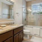 Luxury bathroom remodel in a Florida home with freestanding tub, frameless glass walk-in shower, and natural stone wall